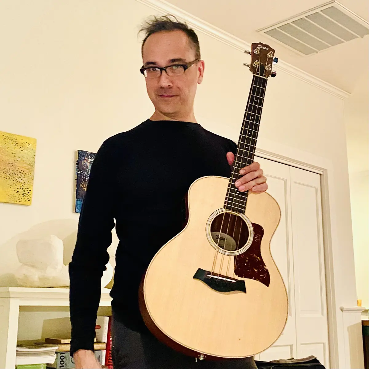 Holding a Taylor GS Mini Bass indoors